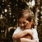Un niño pequeño abrazando a un perro
